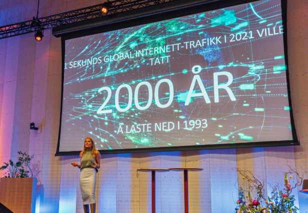 Isabelle Ringnes illustrerte AI-utviklingens fart med et tankevekkende bilde: Ett sekund med global internett-trafikk i 2021 ville tatt 2000 år å laste ned i 1993. Foto: Heine Schjølberg Foto av presentasjon på scene