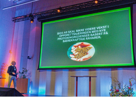 Sigmund Røeggen fra Bio3 presenterte planene for et nytt produksjonsanlegg på Averøy – med bærekraftige proteiningredienser som skal styrke oppdrettsnæringen. Foto: Heine Schjølberg Foto av presentasjon på scene